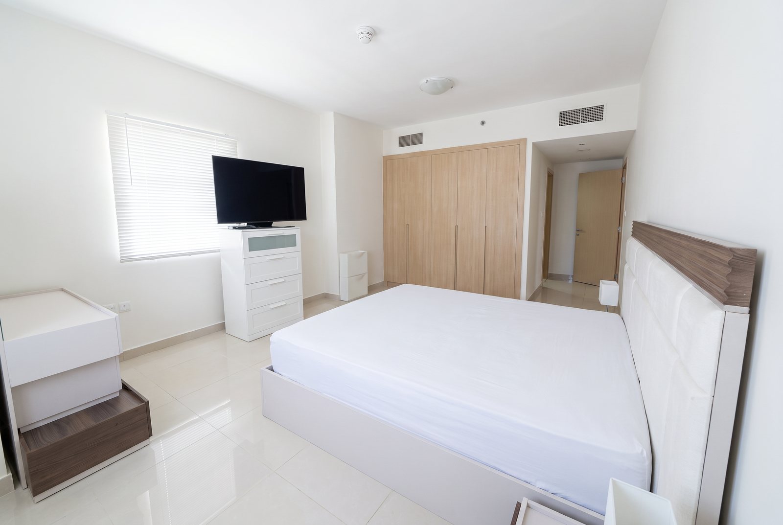 After: the bedroom, bright and straight, with the clutter cleared